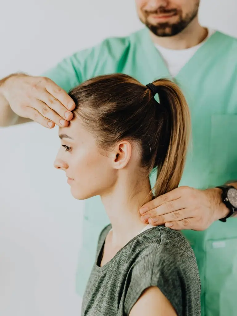 Chiropractor performing a neck adjustment during an on-site chiropractic visit in Central Illinois